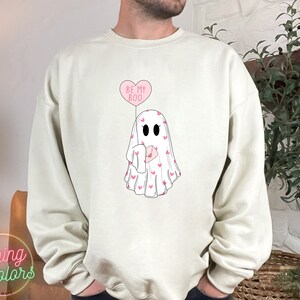 May include: A white sweatshirt with a pink ghost holding a pink heart balloon that says "Be My Boo".