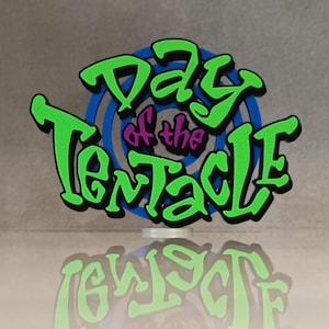 May include: A colorful, three-dimensional sign with the text "Day of the Tentacle." The text is in a vibrant green with a black outline, set against a blue and purple background. The sign is reflected below.