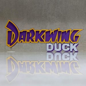 Könnte beinhalten: Ein lila-gelbes "DARKWING DUCK" Logo, mit dem Wort "DUCK" in Weiß darunter. Das Logo spiegelt sich auf einer glänzenden Oberfläche. Das Design ist ein 3D-Rendering.