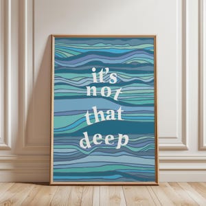 Pode incluir: Uma impressão abstrata azul e verde com o texto "it's not that deep" em branco.