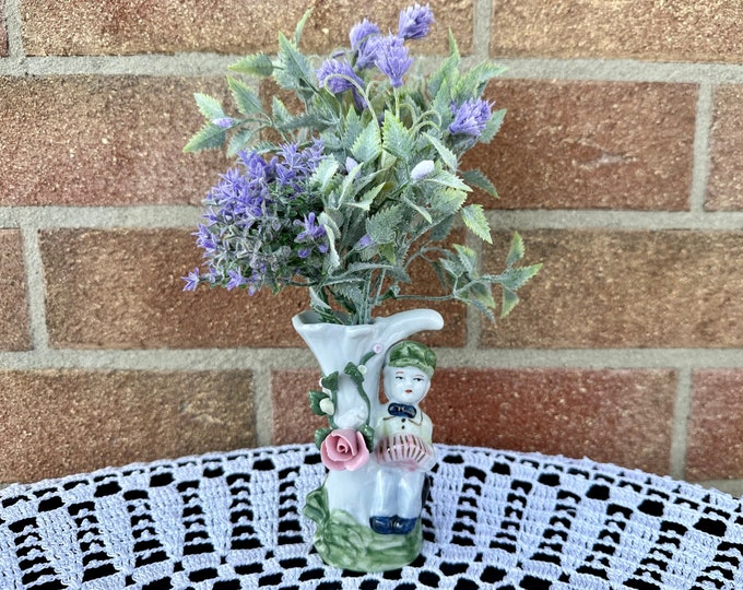 Miniature figurine with pink rose.