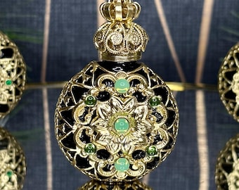 May include: A black and gold decorative bottle with a crown-shaped stopper. The bottle is adorned with intricate filigree designs and green gemstones.