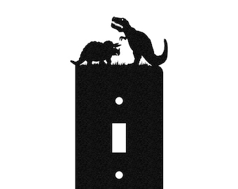 Könnte beinhalten: Schwarzer Lichtschalter-Abdeckung mit einer Silhouette eines Tyrannosaurus Rex und eines Triceratops-Dinosauriers oben.