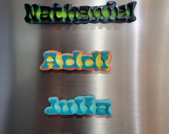 May include: Four colorful, wooden, magnetic names on a stainless steel refrigerator. The names are "Nathaniel", "Addi", "Julia", and "Elysia".