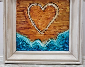 May include: A framed painting of a heart outlined in white on a brown background with blue waves at the bottom.