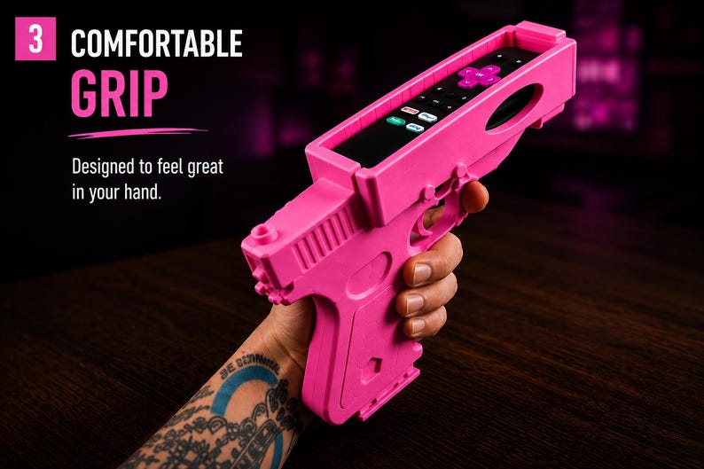 K&ouml;nnte beinhalten: Ein leuchtend pinkfarbener Fernbedienungshalter aus Kunststoff in Pistolenform mit einem rechteckigen Schlitz an der Oberseite f&uuml;r eine schwarze Fernbedienung. Der Text 3 COMFORTABLE GRIP und Designed to feel great in your hand ist aufgedruckt.