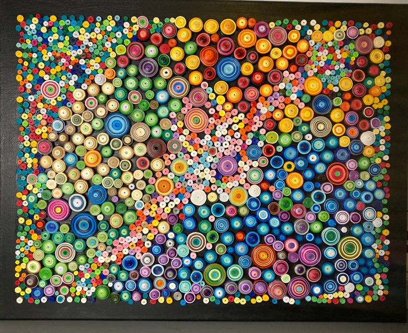 May include: A colorful abstract art piece made of paper circles of various sizes and colors. The circles are arranged in a swirling pattern on a black background.