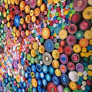 May include: A colorful wall art piece made of rolled paper circles in various sizes and colors. The circles are arranged in a random pattern, creating a visually appealing and textured surface.
