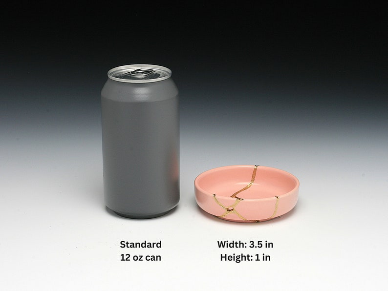 May include: A standard 12 oz aluminum can next to a small pink ceramic bowl with gold crackle lines. The bowl is 3.5 inches wide and 1 inch high.