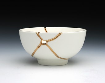 Peut inclure: Un bol en céramique blanche avec des fissures dorées. Le bol est de style japonais traditionnel.