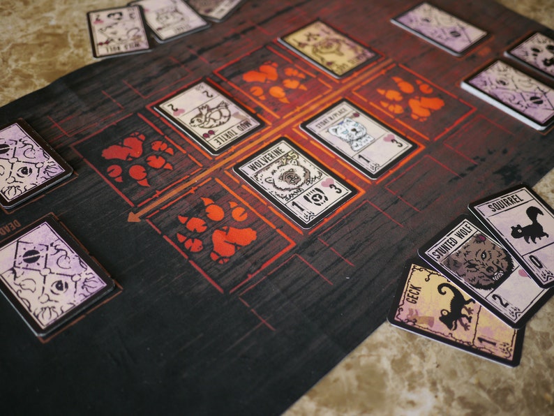 May include: A game board with red paw prints and a grid of squares.  Cards with animal illustrations and numbers are placed on the board.  The cards include "Mud Turtle", "Wolverine", "Space", "Stunt Wolf", "Squirrel", and "Geck".