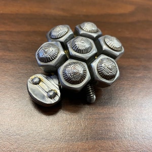 May include: A silver metal sculpture of a turtle made from nuts and bolts.
