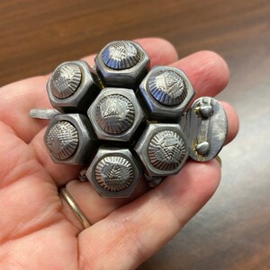 May include: A silver metal turtle sculpture crafted from nuts and bolts. The turtle features a detailed shell and a small head.