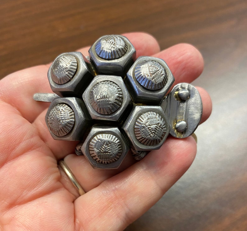 May include: A silver metal turtle sculpture crafted from nuts and bolts. The turtle features a detailed shell and a small head.