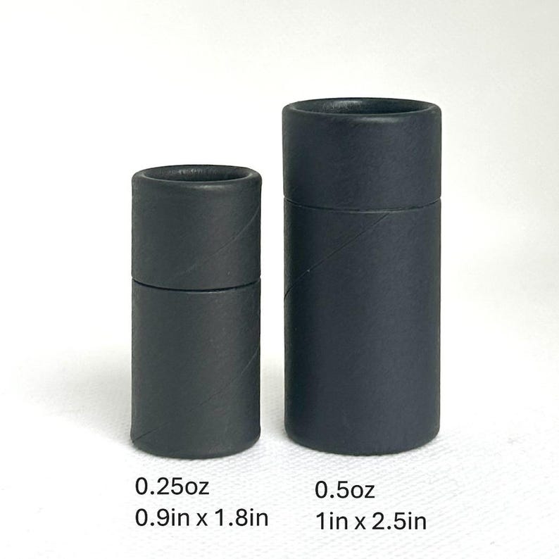 May include: Two black cylindrical cardboard tubes of different sizes. The smaller tube is 0.9 inches in diameter and 1.8 inches tall, holding 0.25 oz. The larger tube is 1 inch in diameter and 2.5 inches tall, holding 0.5 oz.