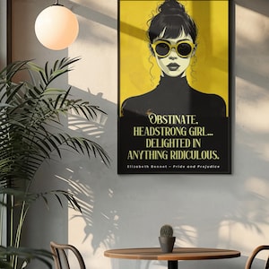 Puede incluir: Un cuadro enmarcado con una mujer con gafas de sol sobre un fondo amarillo. El cuadro incluye la cita "OBSTINATE, HEADSTRONG GIRL... DELIGHTED IN ANYTHING RIDICULOUS." de Elizabeth Bennet en Orgullo y Prejuicio. El cuadro est&aacute; en una habitaci&oacute;n.