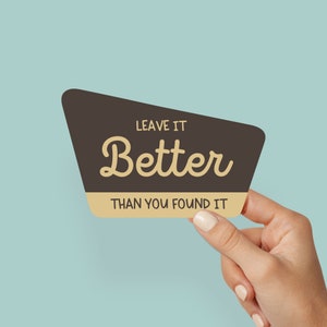 May include: A brown and tan retro-style sign with the text "Leave it Better than you found it".