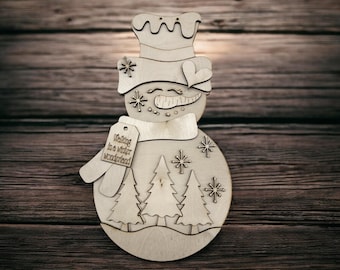 May include: Wooden snowman ornament with a hat, scarf, and a tag that reads "Walking in a winter wonderland." The snowman has a smiling face, snowflakes, and a forest scene. A charming holiday decoration.
