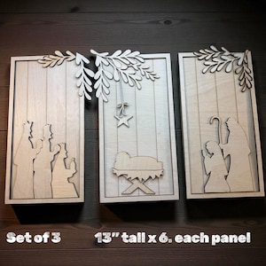 May include: Set of three wooden panels, each 13 inches tall and 6 inches wide, featuring laser-cut Nativity scenes. The panels depict the Three Wise Men, the Nativity scene, and Mary and Joseph. Each panel is topped with a decorative leaf design.