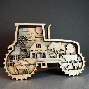 May include: A wooden tractor-shaped decorative piece featuring a farm scene. The design includes a barn, windmill, trees, animals, and a sun. The layered wood construction creates a 3D effect, showcasing a rural landscape.