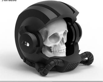 May include: A black helmet with a skull inside. The helmet has a striped design and a visor that is partially open. The skull is white and has a detailed design. The helmet has a label that says "TORUA3D" and "SKULL 005".