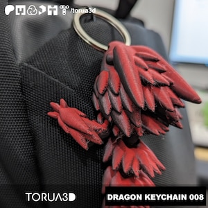 May include: Red and black dragon keychain with a silver keyring. The dragon has detailed wing and body features. The text "DRAGON KEYCHAIN 008" is displayed on the bottom right.