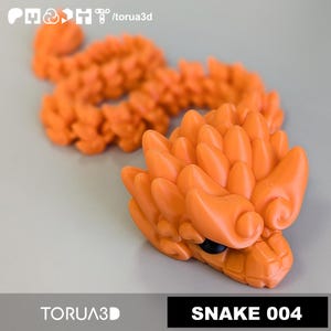 Könnte beinhalten: Orangefarbene 3D-gedruckte Schlangenfigur mit detailliertem, strukturiertem Design. Der Kopf der Schlange ist im Fokus, mit schwarzen Augen und einem detaillierten Maul. Die Texte "TORUA3D" und "SNAKE 004" sind sichtbar.
