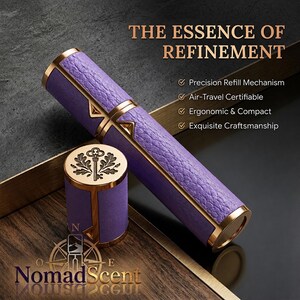 May include: A purple and gold perfume atomizer with the text "THE ESSENCE OF REFINEMENT". The atomizer has a textured purple body with gold accents and a matching cap. The cap features a key design. The brand name "Nomad Scent" is also visible.