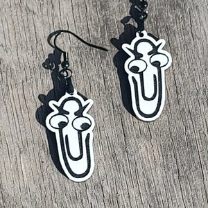 May include: A pair of black and white earrings shaped like a paperclip with googly eyes.
