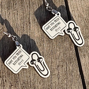 May include: A pair of silver earrings with a paperclip design and a speech bubble that says "Have you tried restarting it??".