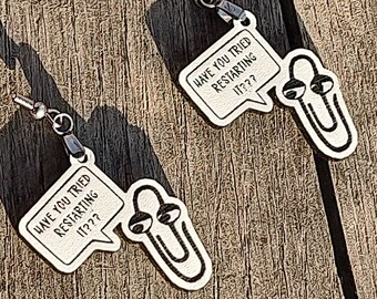 May include: A pair of silver earrings with a paperclip design and a speech bubble that says "Have you tried restarting it??".