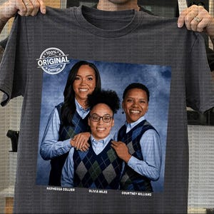 May include: A charcoal gray t-shirt featuring a printed photograph of three individuals wearing light blue button-down shirts and navy blue argyle sweater vests. The text "100% ORIGINAL Design" appears in a circular badge, with names printed below.