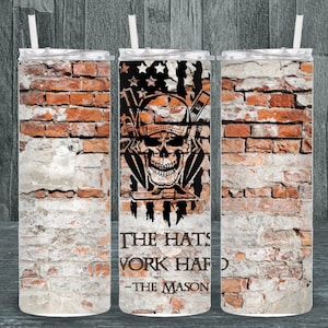Puede incluir: Un vaso de acero inoxidable con un diseño de pared de ladrillo. El vaso presenta una calavera con un casco y herramientas, y el texto "The Hats Work Hard - The Mason".