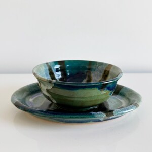May include: A blue and green ceramic bowl with a matching saucer. The bowl and saucer have a striped pattern.