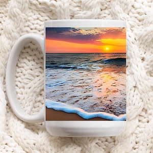May include: White ceramic mug with a colorful sunset over the ocean scene. The mug has a large handle and a wide base.