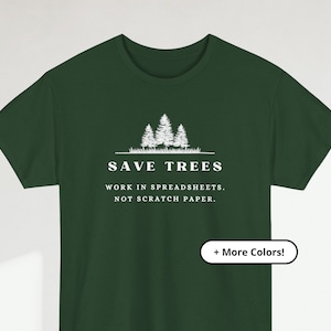 May include: Dark green t-shirt with white text and graphic. The text reads "SAVE TREES" above "WORK IN SPREADSHEETS. NOT SCRATCH PAPER." A graphic of three trees is above the text. The shirt also has a "+ More Colors!" button.