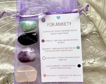 Pode incluir: Uma bolsa roxa contendo um kit de cristais para ansiedade. O kit inclui cristais de Lepidolita, Amazonita, Quartzo claro, Turmalina negra e Quartzo rosa. A bolsa tem uma etiqueta que diz "Para ansiedade" e lista os cristais e suas propriedades.