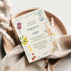 a wedding invitation card with a decorative border and various illustrations, including grapes, a vase, and other food items.