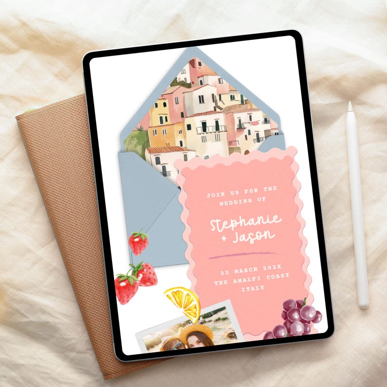The image is a wedding invitation featuring a colorful illustration of a coastal town, with the names 'Stephanie & Jason' and the date '22 MARCH 2023' printed on it. The invitation is displayed on a tablet, with a pen and a piece of paper visible in the background.