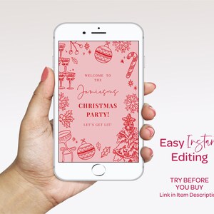 A hand holding a white smartphone displaying a pink Christmas-themed design with various Christmas decorations and text.