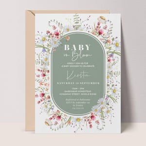 May include: A baby shower invitation with a floral design. The invitation features the text "Baby in Bloom" in elegant script, with details for the event, including the date, time, and location. The design includes daisies and other wildflowers.