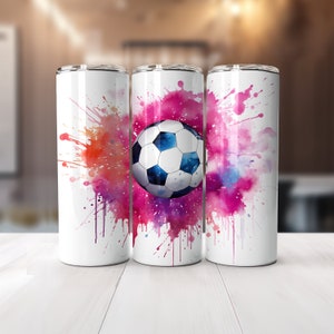 May include: Three white stainless steel tumblers with a watercolor design of pink, purple, and orange paint splatters. A soccer ball is in the center of the design on the middle tumbler.