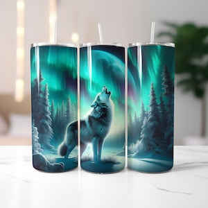 May include: Three stainless steel tumblers with a wolf howling at the moon under a green and blue aurora borealis. The tumblers are on a white surface.
