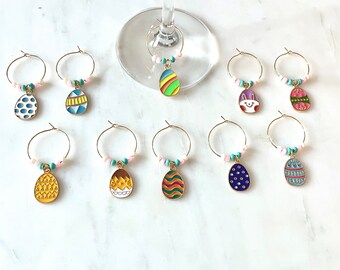 May include: Set of ten gold-tone Easter egg-shaped wine glass charms. Each charm features a different colourful Easter egg design with white beads.