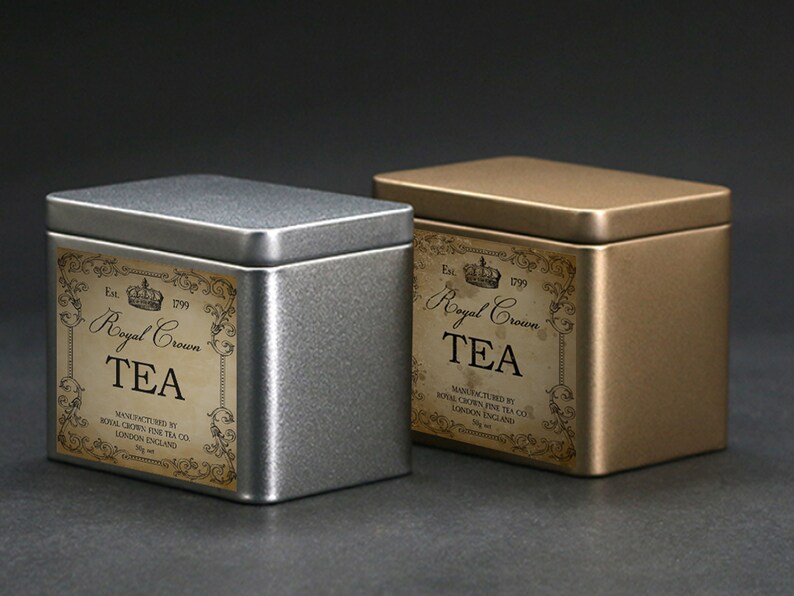 May include: Two metal tea tins, one silver and one gold, with rectangular labels. The labels read "Royal Crown TEA" with ornate scrollwork and the text "Manufactured by Royal Crown Fine Tea Co. London England."