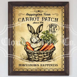 Könnte beinhalten: Gerahmter Vintage-Druck mit einem Kaninchen in einem Korb mit Karotten und Grünzeug. Der Druck trägt die Aufschrift "Hoppington Farm Carrot Patch Since 1896" und "Open Daily". Das Kunstwerk hat ein rustikales Aussehen in einem braunen Holzrahmen.
