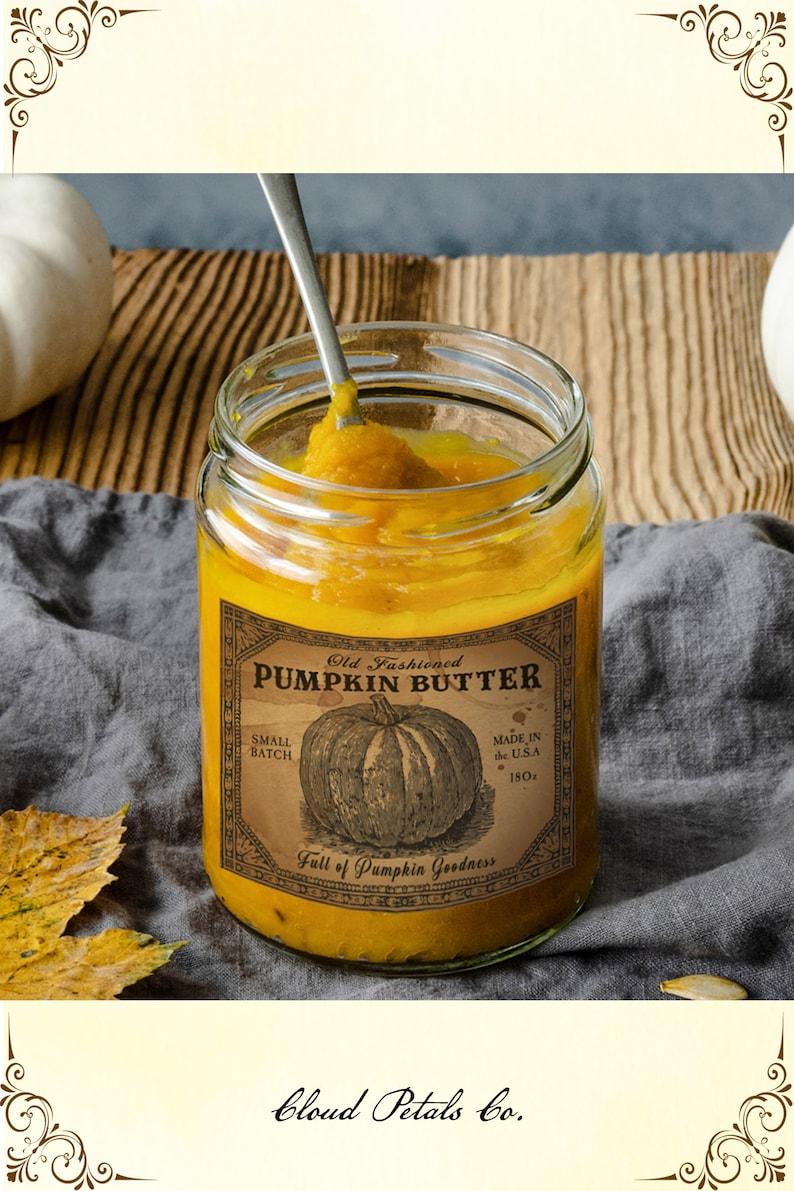 May include: A jar of pumpkin butter with a vintage label that reads "Old Fashioned Pumpkin Butter." The label features a pumpkin illustration and the text "Made in the U.S.A., 18oz." A spoon is in the jar, scooping out the orange butter. The text "Cloud Petals Co." is at the bottom.