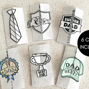 K&ouml;nnte beinhalten: Sechs gefaltete Papierkarten mit Vatertagsmotiven. Die Karten zeigen Illustrationen einer Krawatte, eines Schildes mit F&auml;usten, einer Troph&auml;e, einer Baseballkappe und Abzeichen mit den Worten "Super Dad" und "Bester Papa". Der Text "6 KARTEN ENTHALTEN" ist ebenfalls sichtbar.