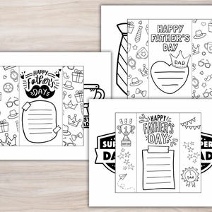 K&ouml;nnte beinhalten: Drei schwarz-wei&szlig;e Vatertagskarten mit dekorativen Elementen. Jede Karte enth&auml;lt den Text "Happy Father's Day" und Platz f&uuml;r eine Nachricht. Eine Karte hat die Form einer Krawatte, eine andere die eines Herzens und die dritte einen Pokal.