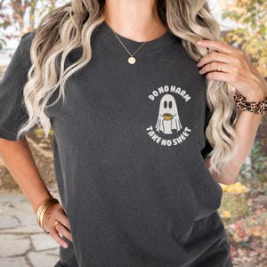 Peut inclure: T-shirt gris fonc&eacute; avec un motif de fant&ocirc;me tenant une tasse &agrave; caf&eacute; et le texte "DO NO HARM TAKE NO SHEET". Un style confortable et d&eacute;contract&eacute;.